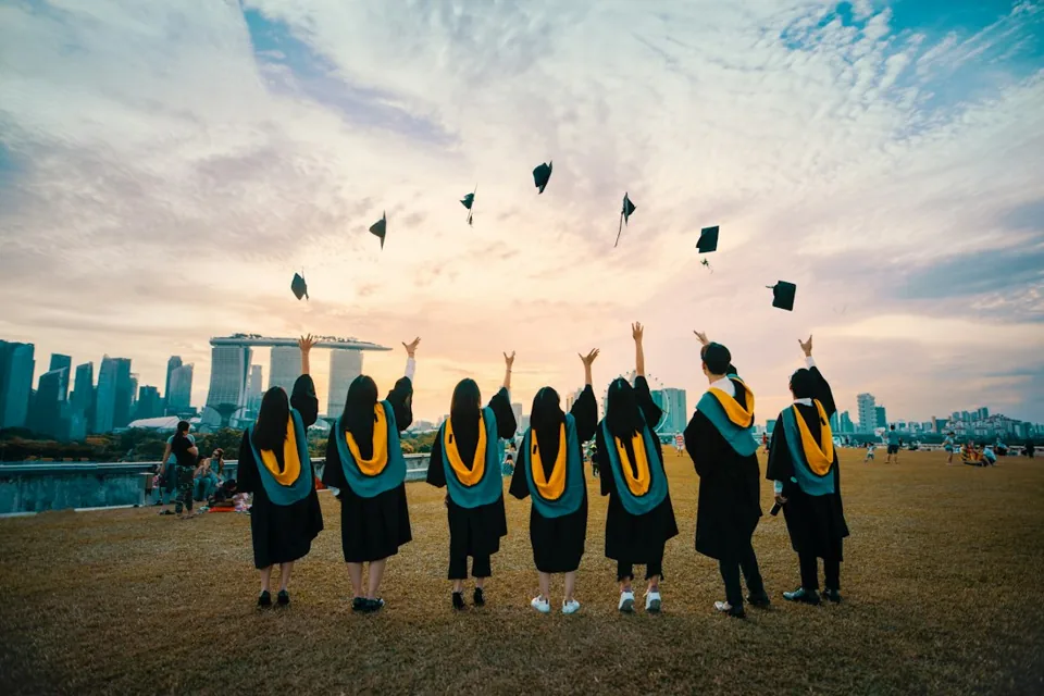 Graduates celebrating on a university campus; illustrative study-abroad photography